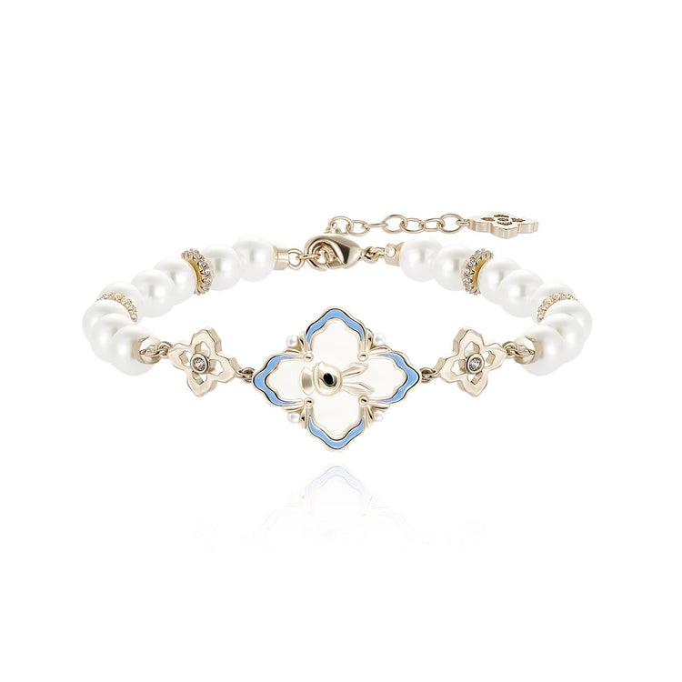 A white pearl bracelet with a central blue and white clover charm.
