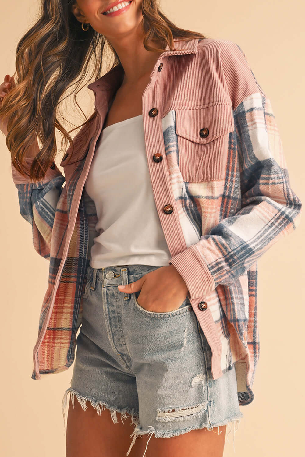 Woman wearing a pink plaid corduroy shirt, styled casually with jeans for a trendy look.