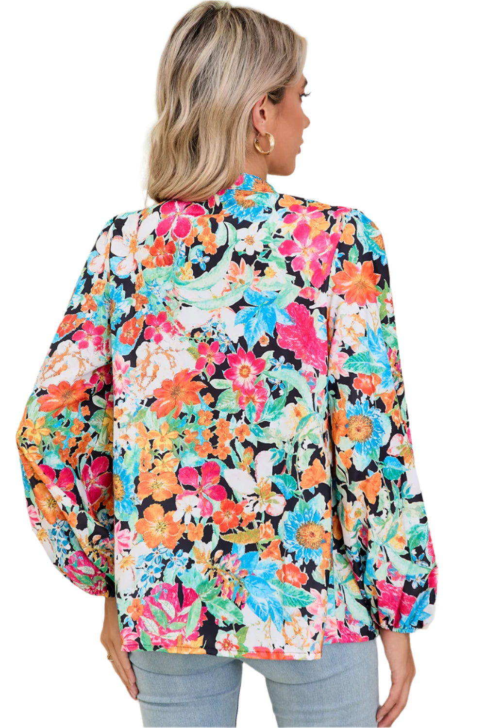 Back view of model wearing multicolour floral blouse with long lantern sleeves.