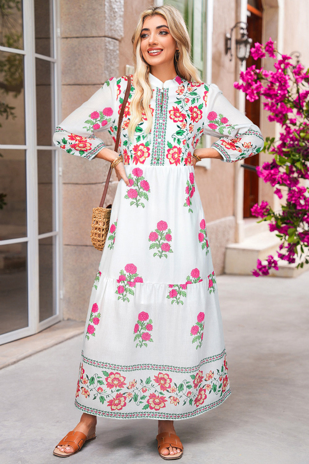Woman wearing a floral dress standing outdoors with flowers in the background