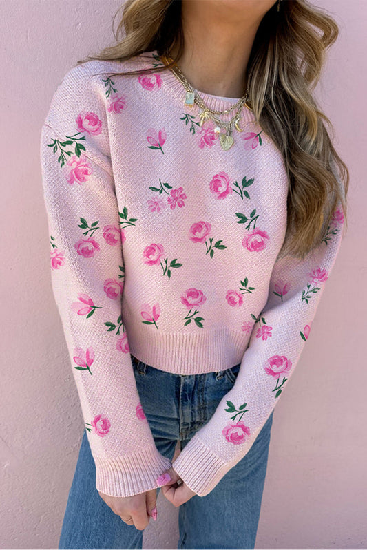 Pink floral sweater worn by a person against a pink background