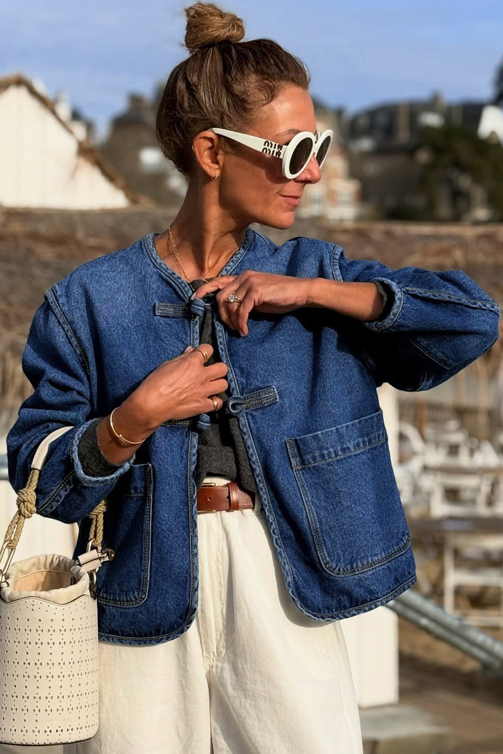 Woman wearing a denim jacket and sunglasses outdoors