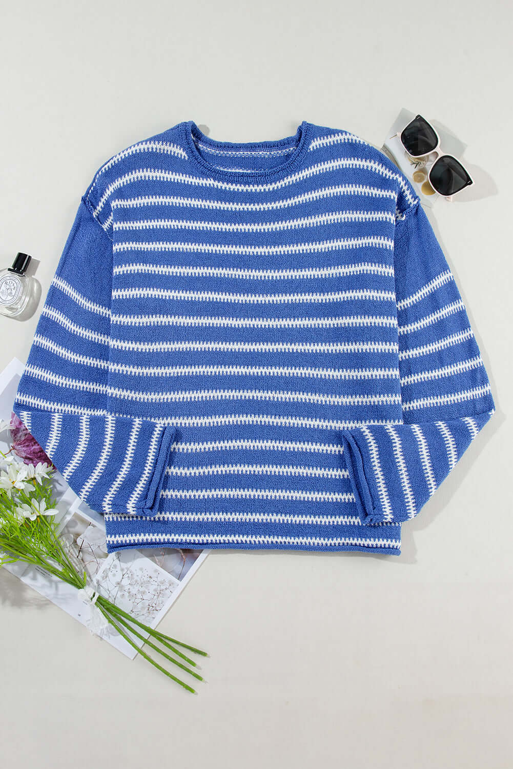 Back view of the blue striped jumper, highlighting its relaxed drape and long sleeves.