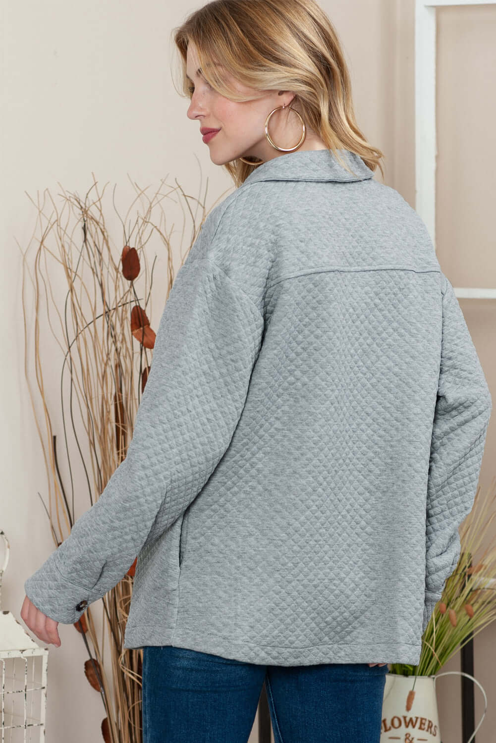 Back view of the gray quilted jacket, showing its sleek and flattering fit.