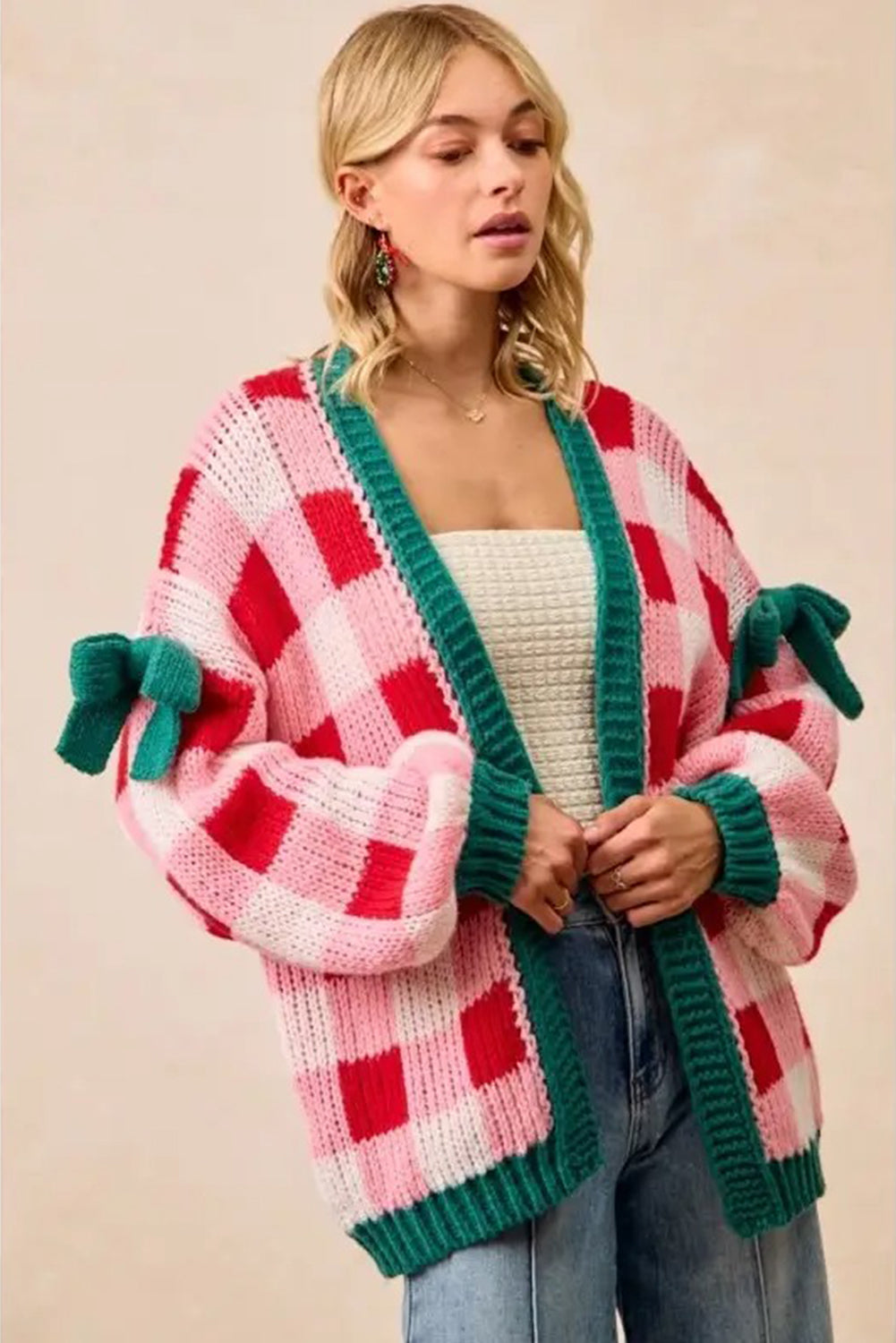 Woman wearing a colorful checkered cardigan with green accents on a beige background