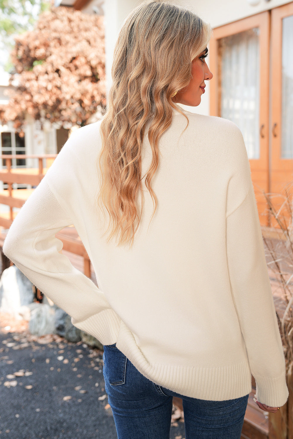 Woman wearing a cream sweater with a blurred background
