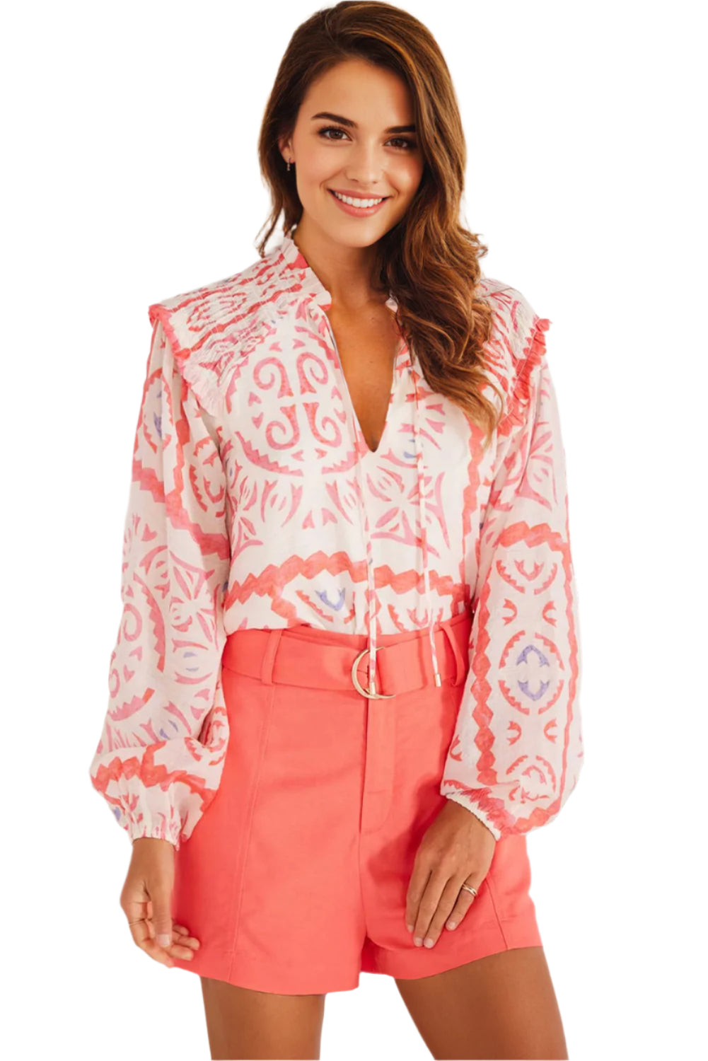 Light orange abstract print with long puff sleeves. Indoor setting.