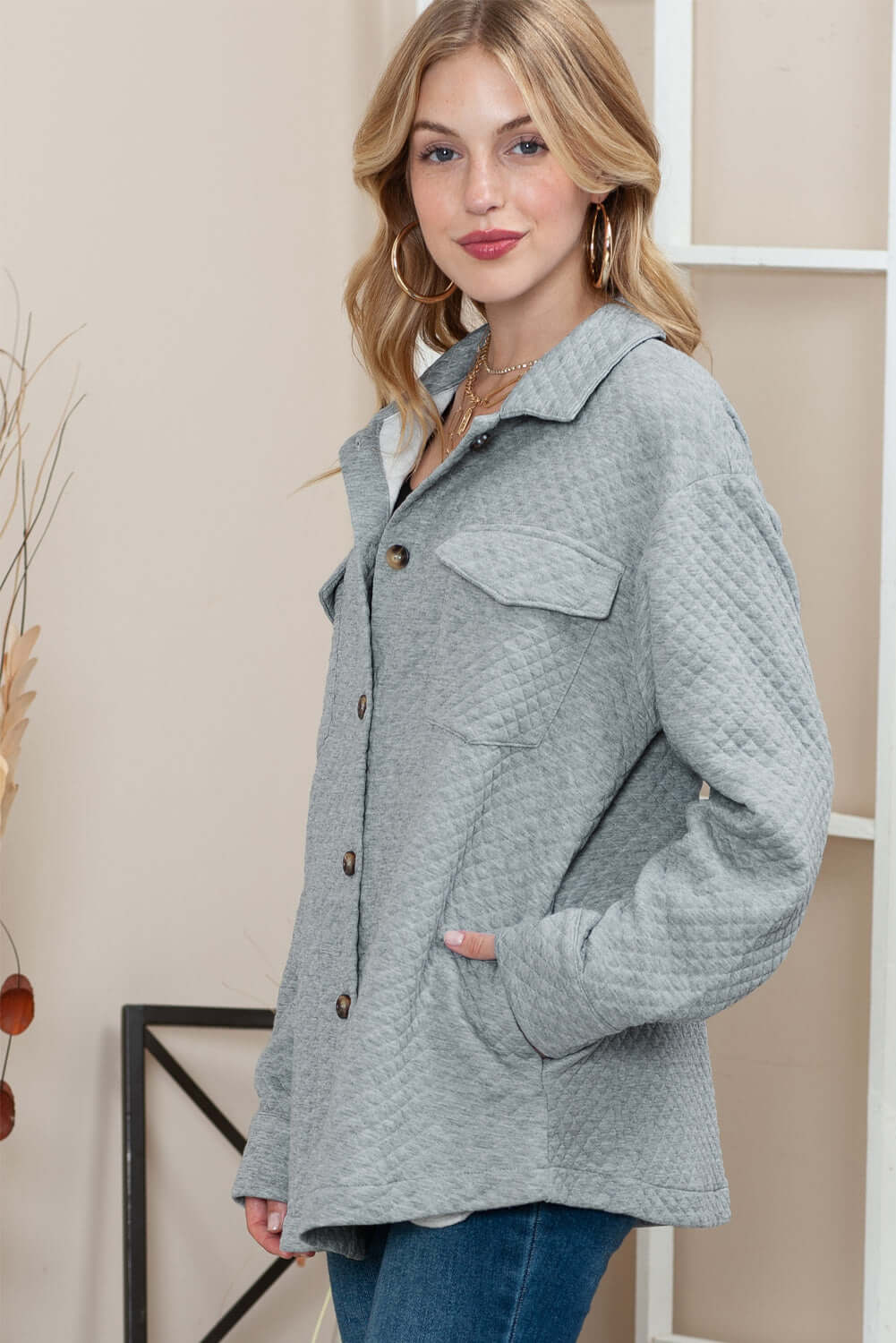 Woman wearing a longline quilted jacket with a stylish lattice texture.