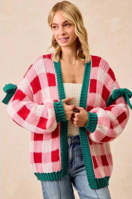 Woman wearing a colorful checkered cardigan with green trim on a beige background