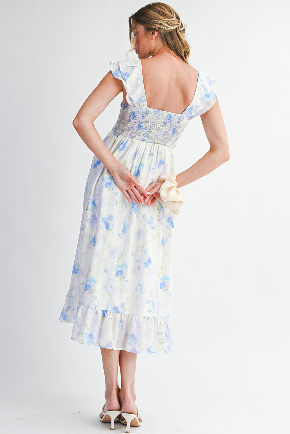 Woman wearing a floral dress with a plain background