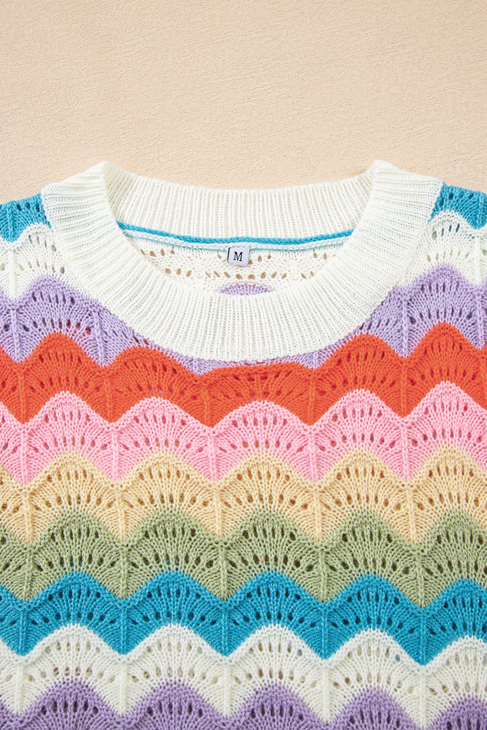 Colorful knitted sweater with a pattern on a beige background