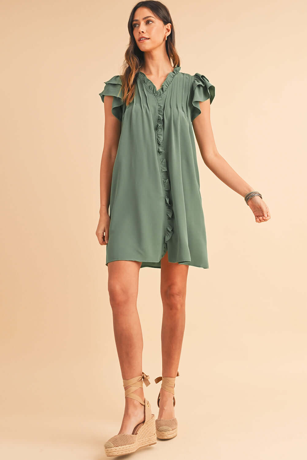Model walking in a flowy ruffle front dress perfect for summer days.