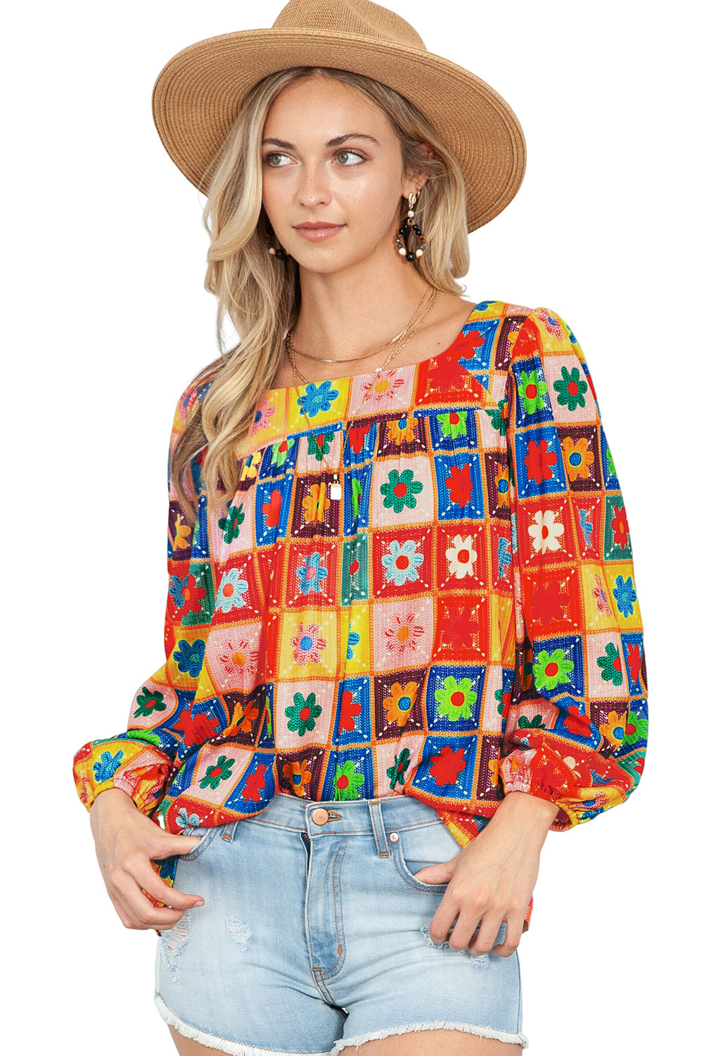 Woman wearing a colorful patchwork blouse and straw hat on a white background