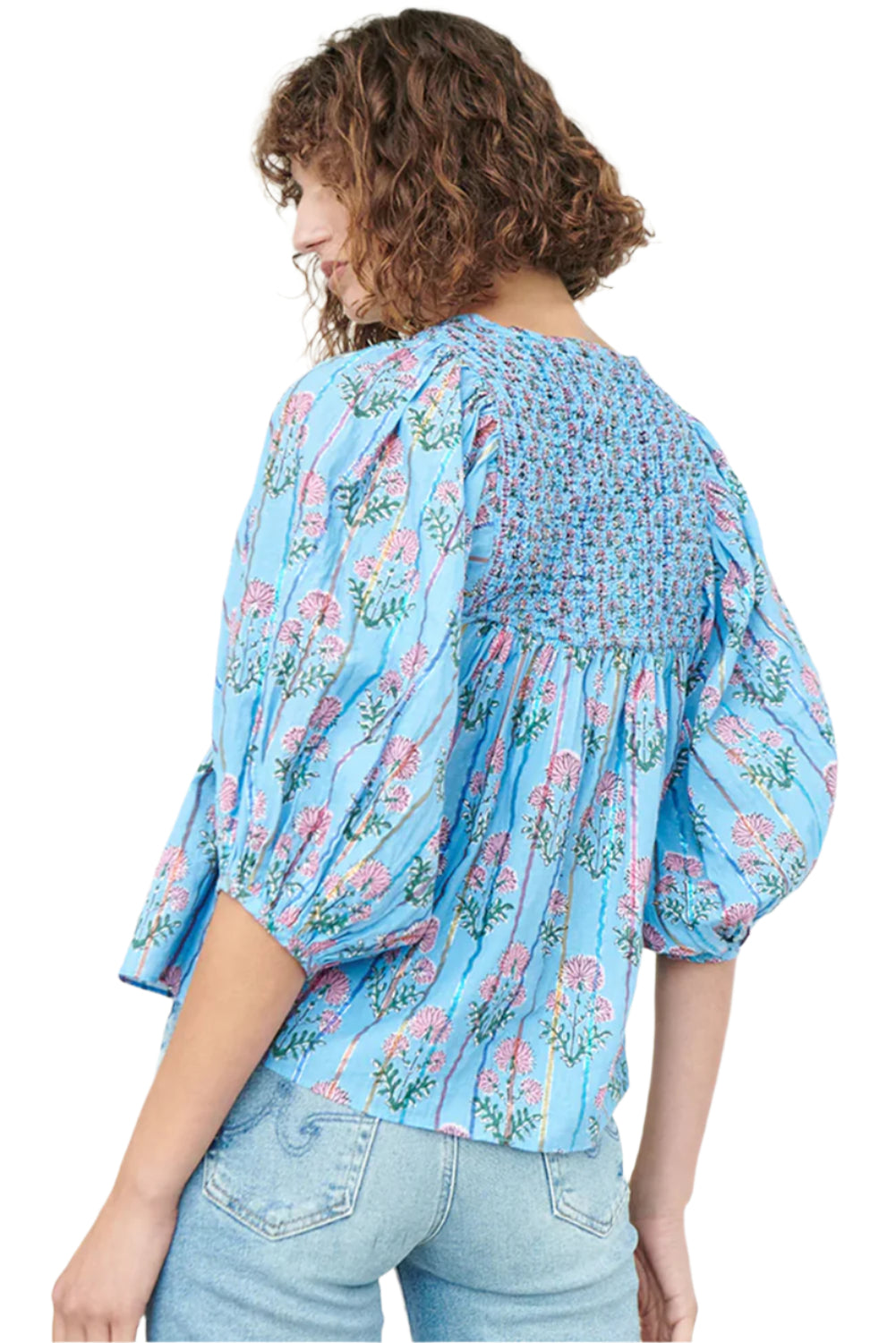 Model standing with her back turned in a light blue striped floral blouse with half sleeves.