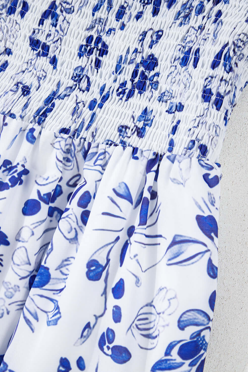 Close-up of soft lightweight fabric with blue floral print on a tiered maxi dress.