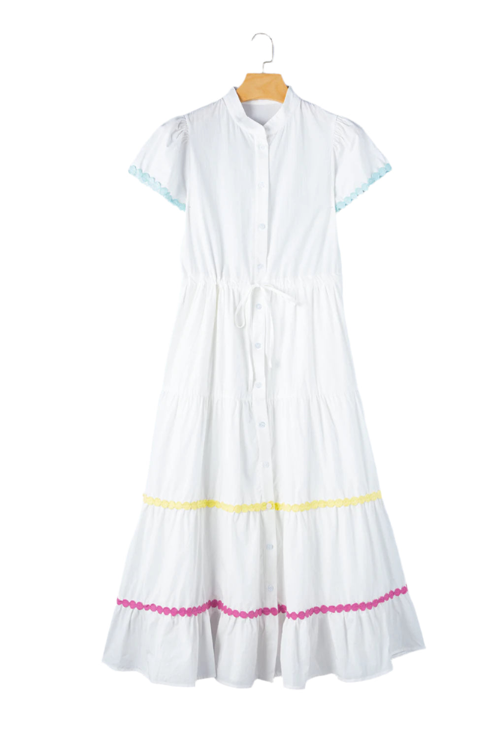 Full front view of a white tiered shirt dress with short sleeves and a waist tie displayed on a hanger, showcasing its elegant design.