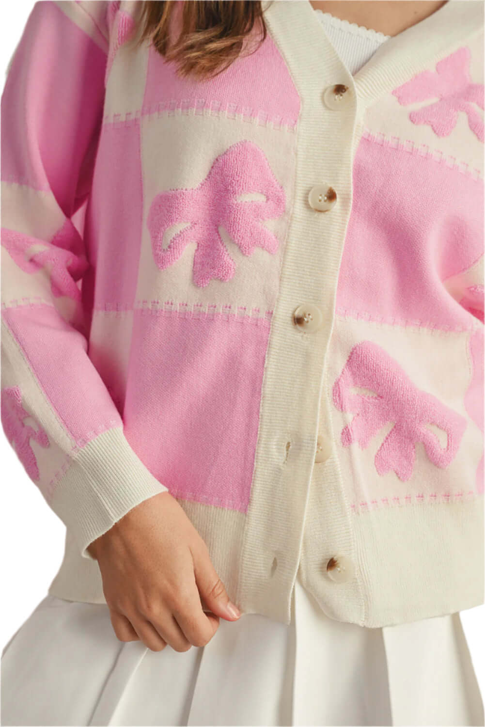 Close-up of soft pink knit cardigan with button-up front and playful palm design.