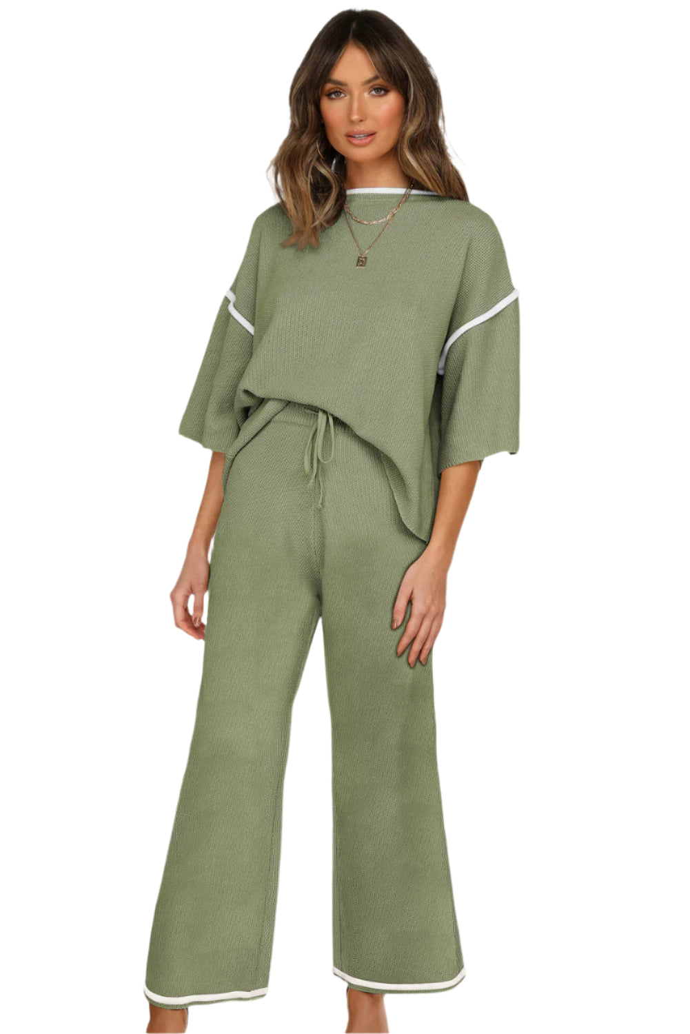 Woman wearing a green outfit with white trim on a white background