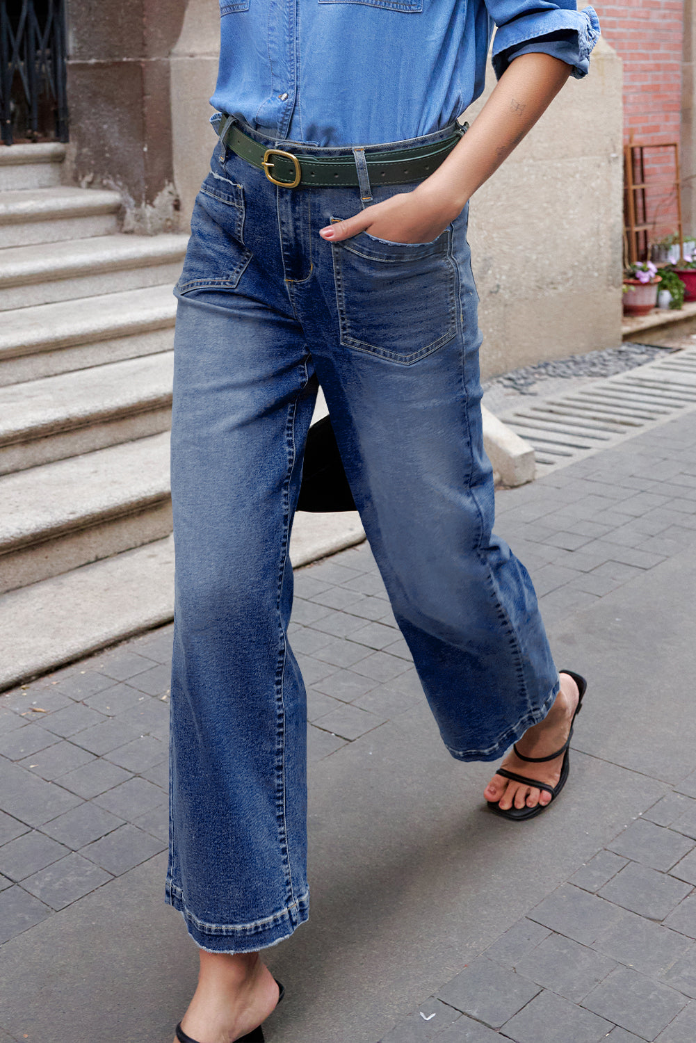 Person wearing blue jeans and a denim shirt on a street.