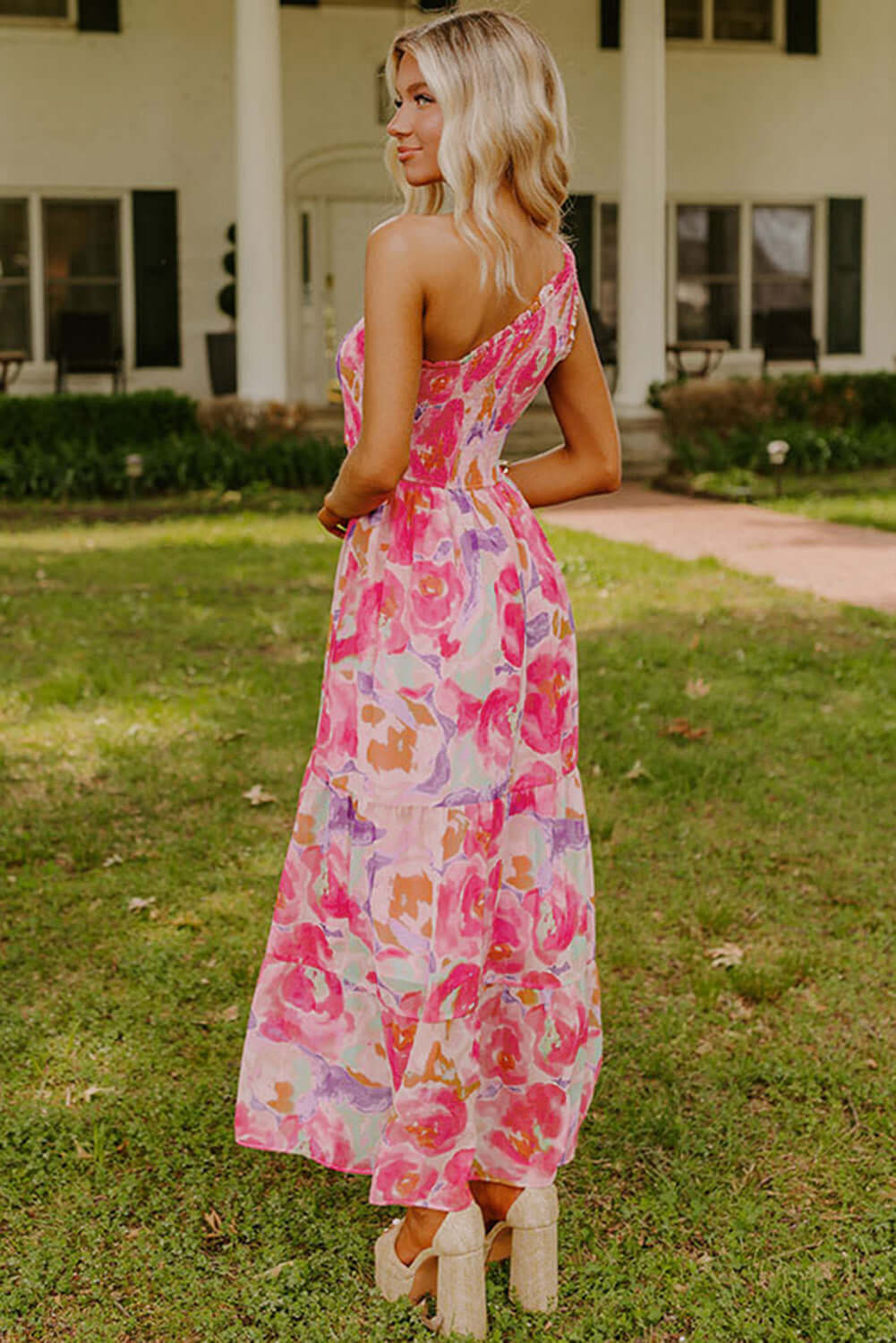 Rosy Sunset One-Shoulder Dress. Back view. Outdoor setting.