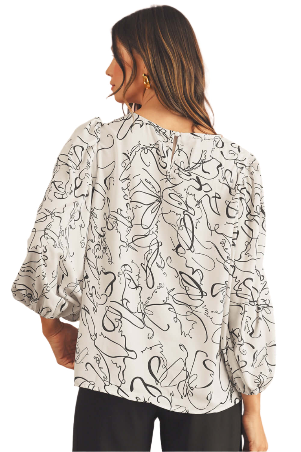 The back view of black and beige blouse, featuring crew and balloon sleeves.