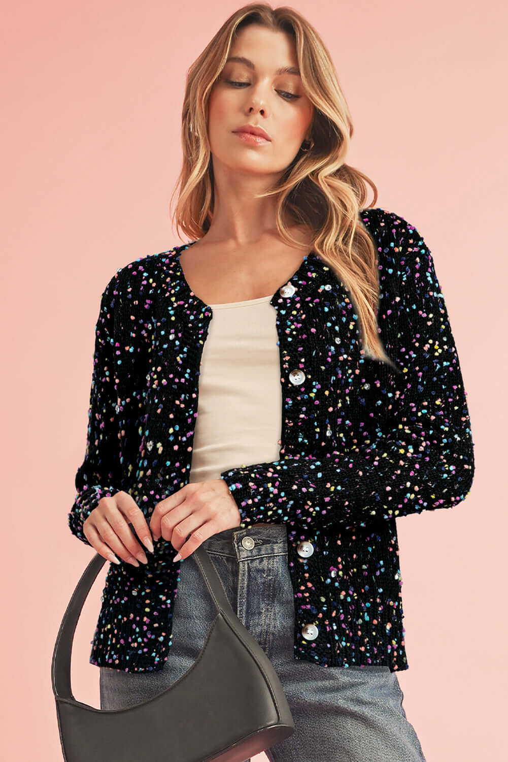 Woman wearing a black sparkle knit cardigan with button-up front and relaxed fit.