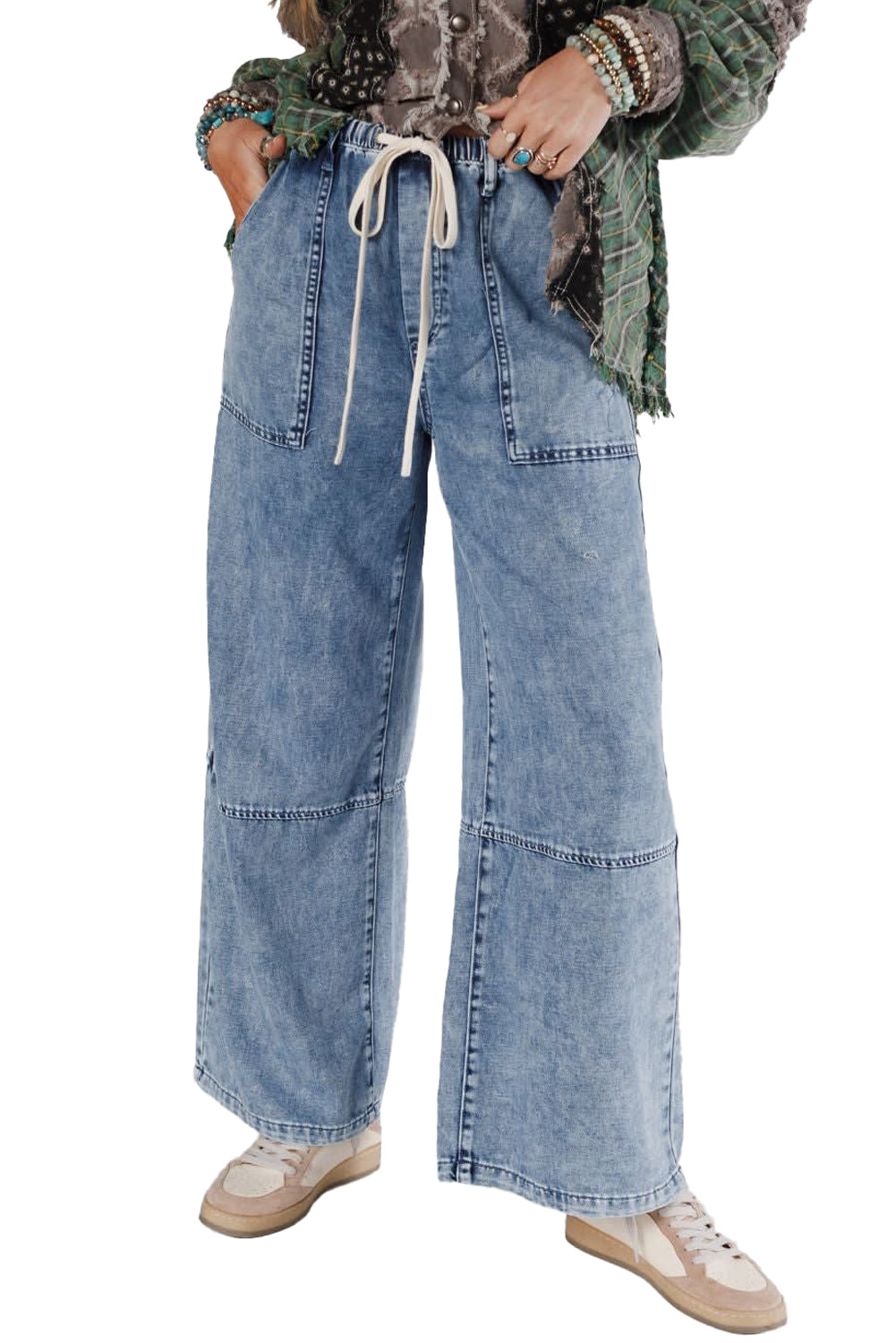 Wide-leg blue jeans worn by a person on a white background