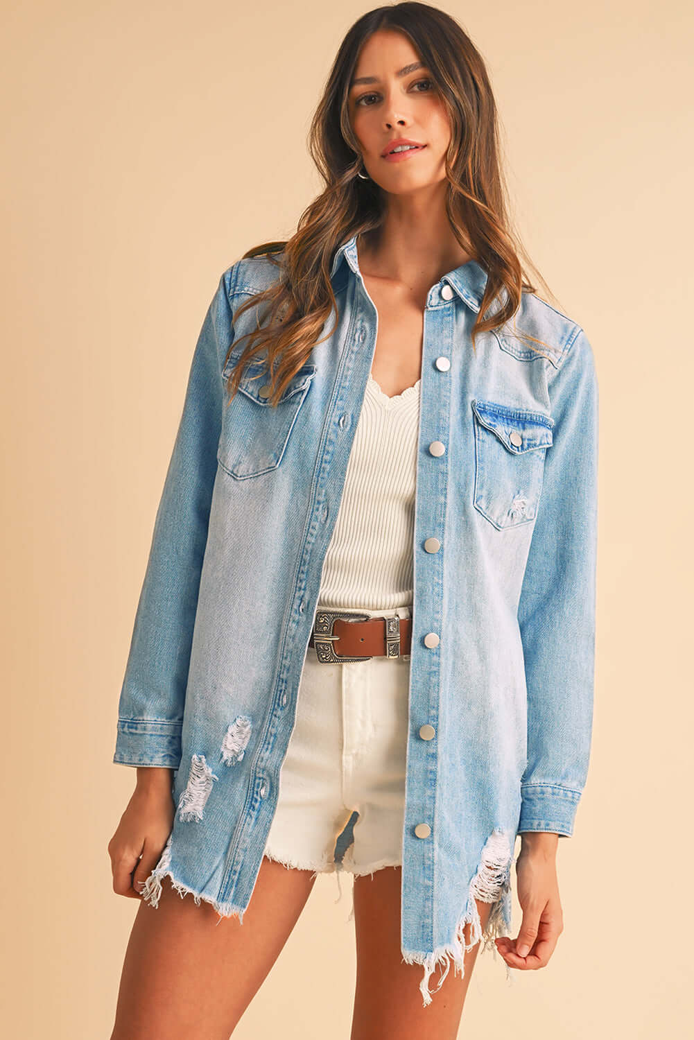 Woman wearing a ripped denim jacket, styled for an effortless streetwear look.