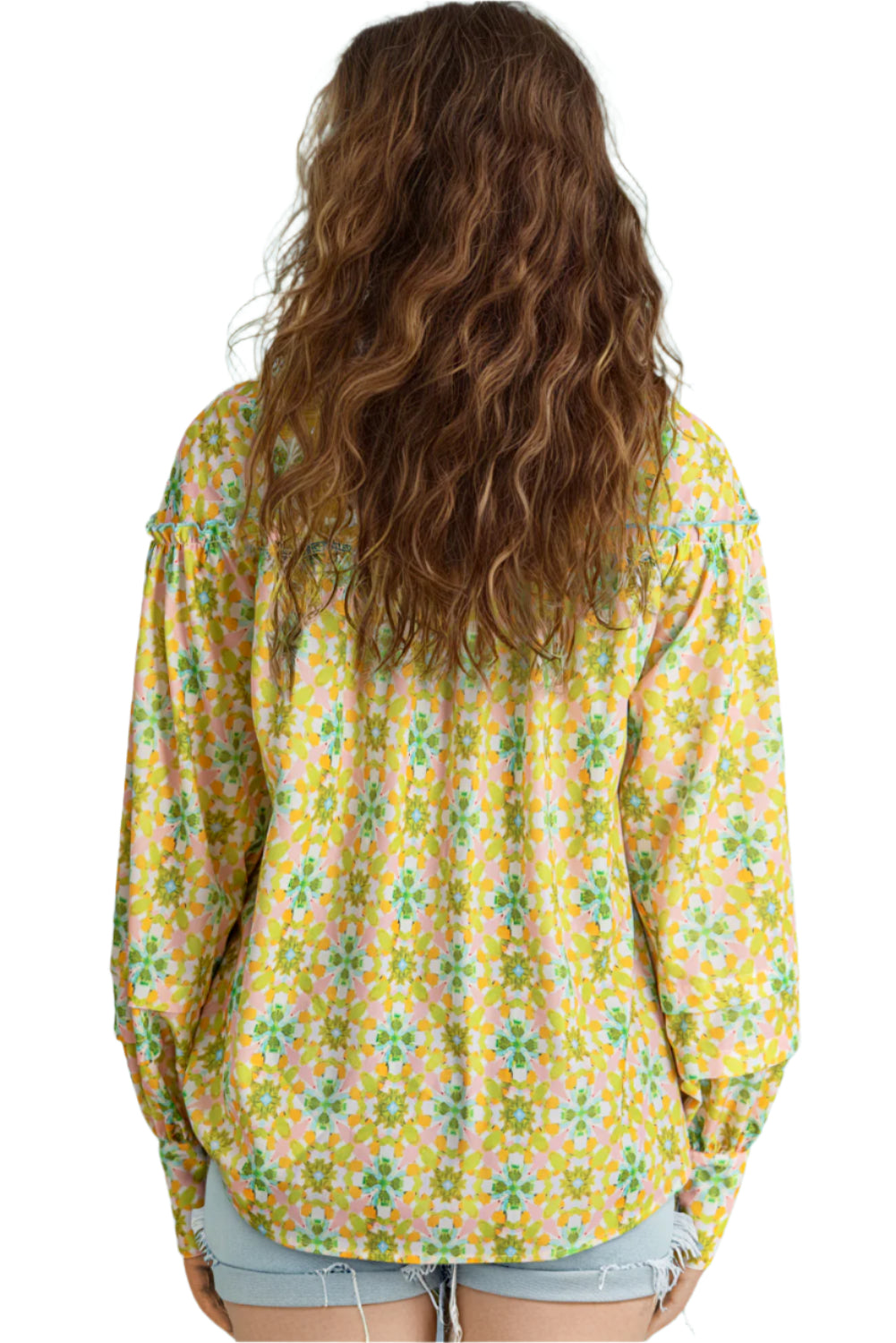 Back view of a green and yellow floral blouse with balloon sleeves.