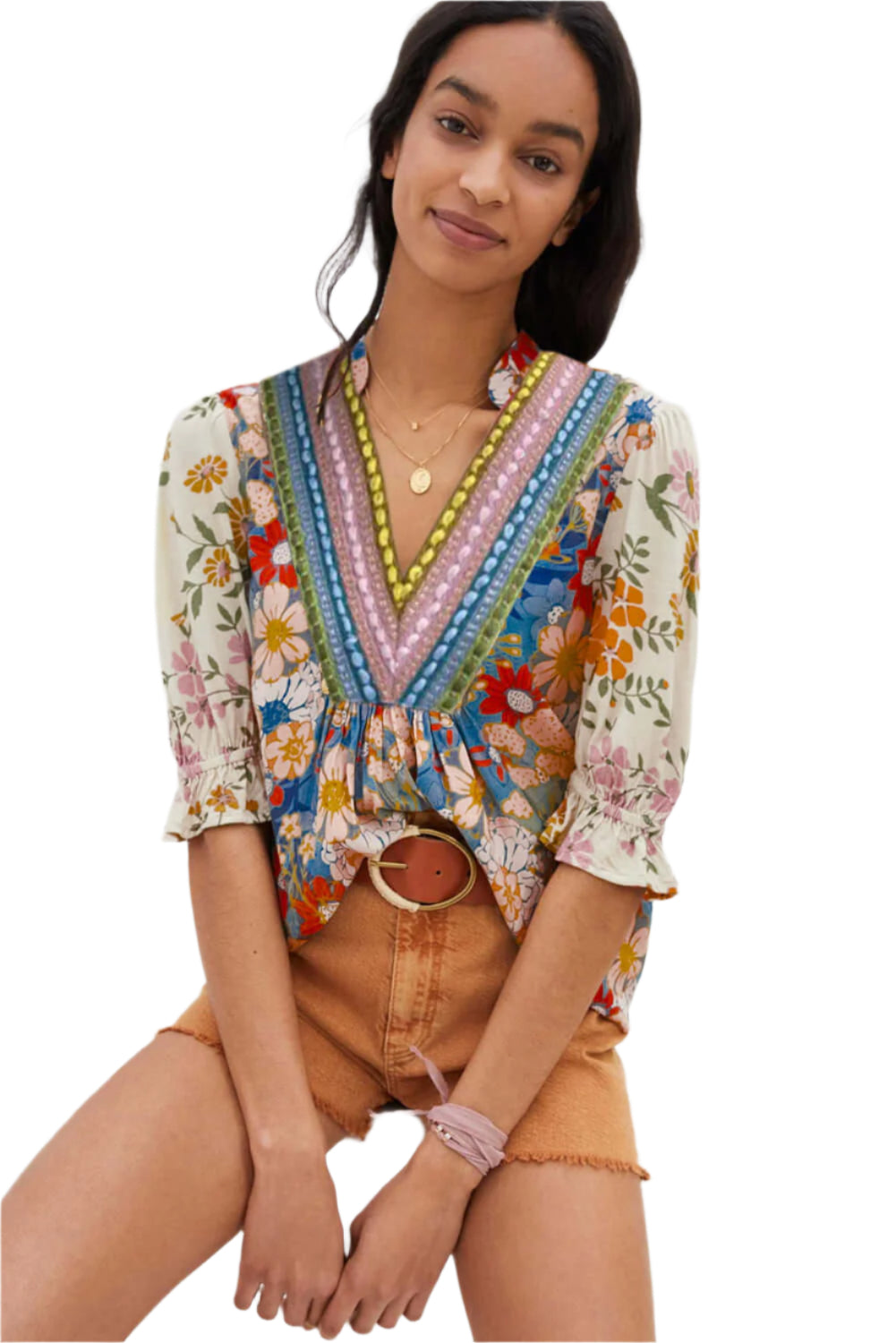 A model sitting in a multicolor boho blouse with a V-neck and half sleeves.