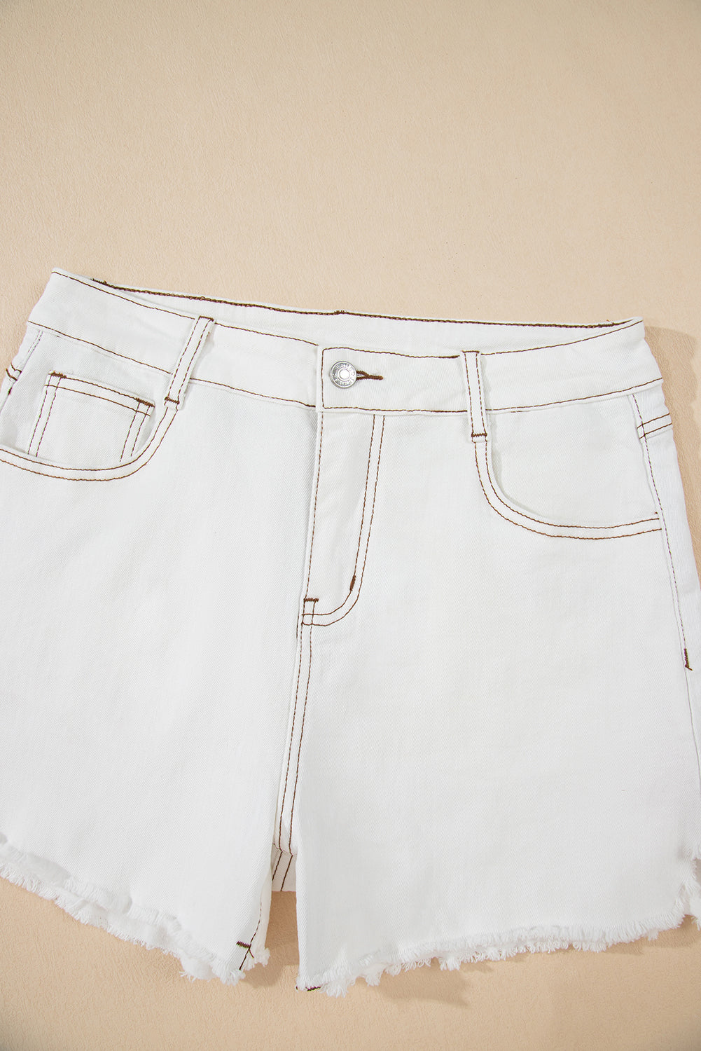 White denim shorts on a beige background