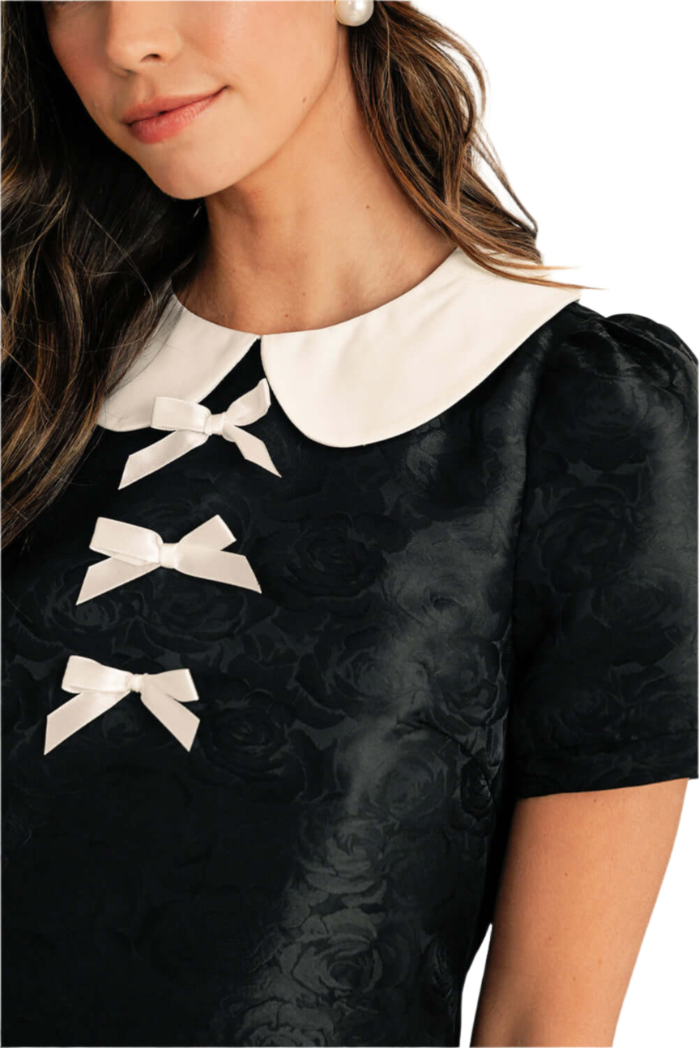 Detail of the high-quality fabric used in the elegant black mini dress. Front detail view.