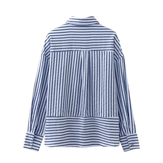 The back view of a blue and white striped shirt showcasing a horizontal back yoke, central box pleat, and dropped shoulder design.