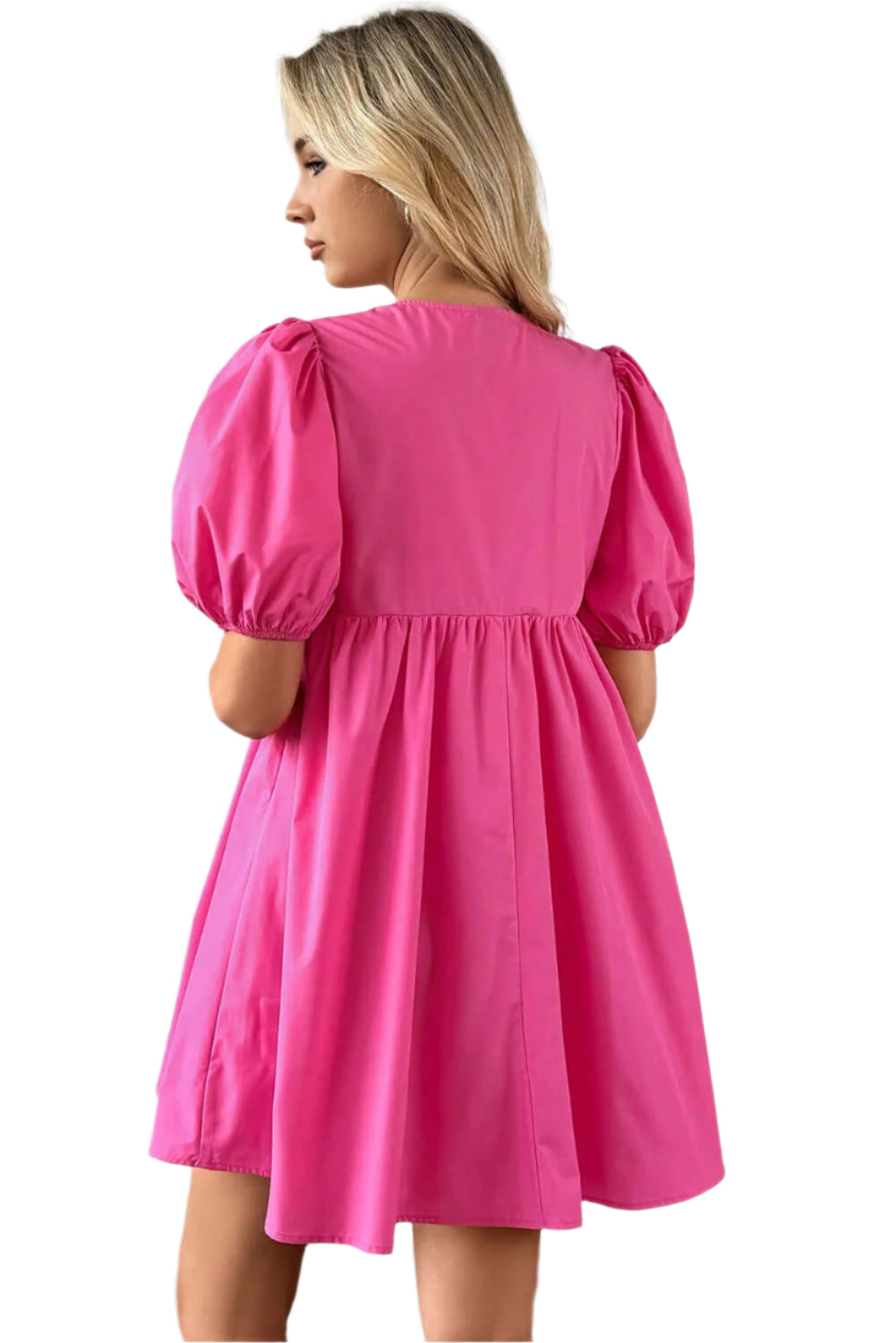 Back view of a bright pink puff sleeve mini dress, showcasing its flowy design and feminine silhouette, styled indoors with soft lighting.