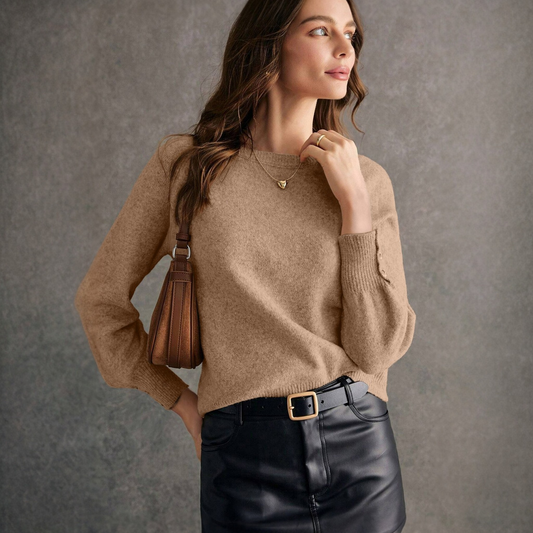 Women's camel knit jumper with button cuff detail worn with black
leather skirt — soft lifestyle fashion photography