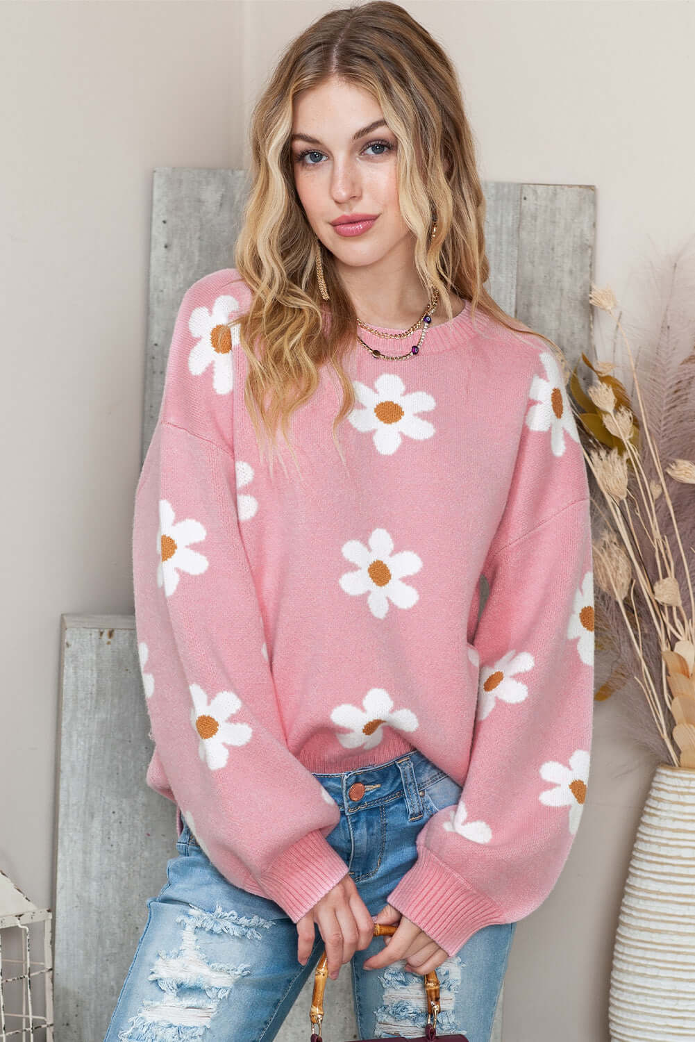 Pink floral knit sweater for women styled with jeans.