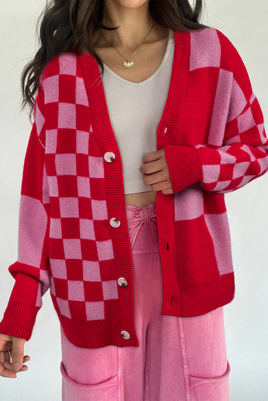 Person wearing a red and pink checkered cardigan over a white top and pink pants.