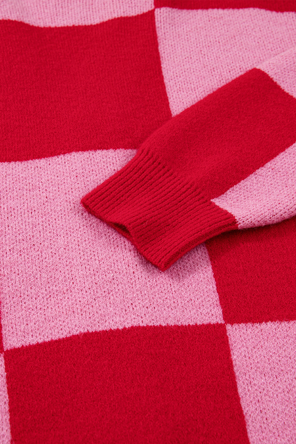 Close-up of a red and pink checkered fabric with a folded edge.
