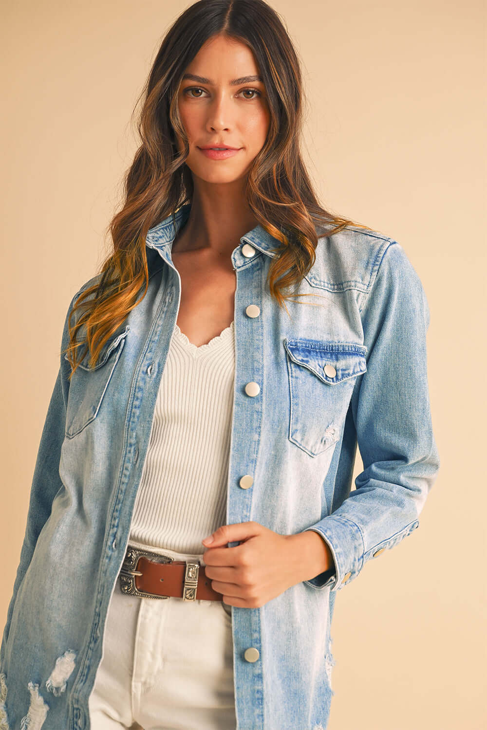Close-up of light wash denim jacket featuring stylish distressed details.