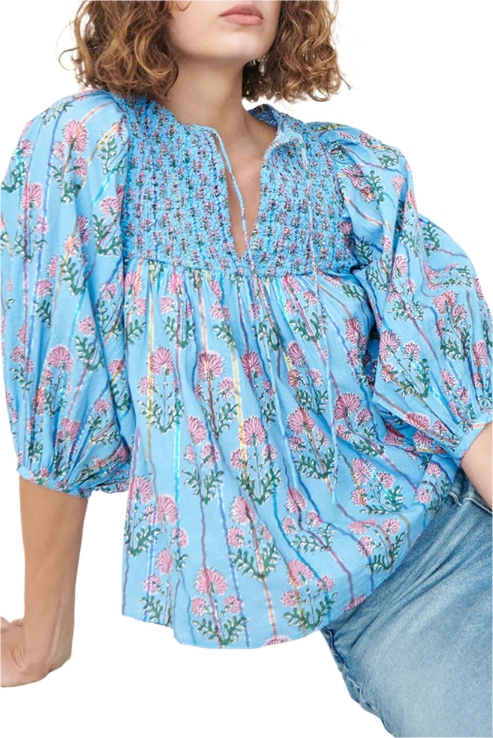 Model sitting in a light blue striped floral blouse with half sleeves.
