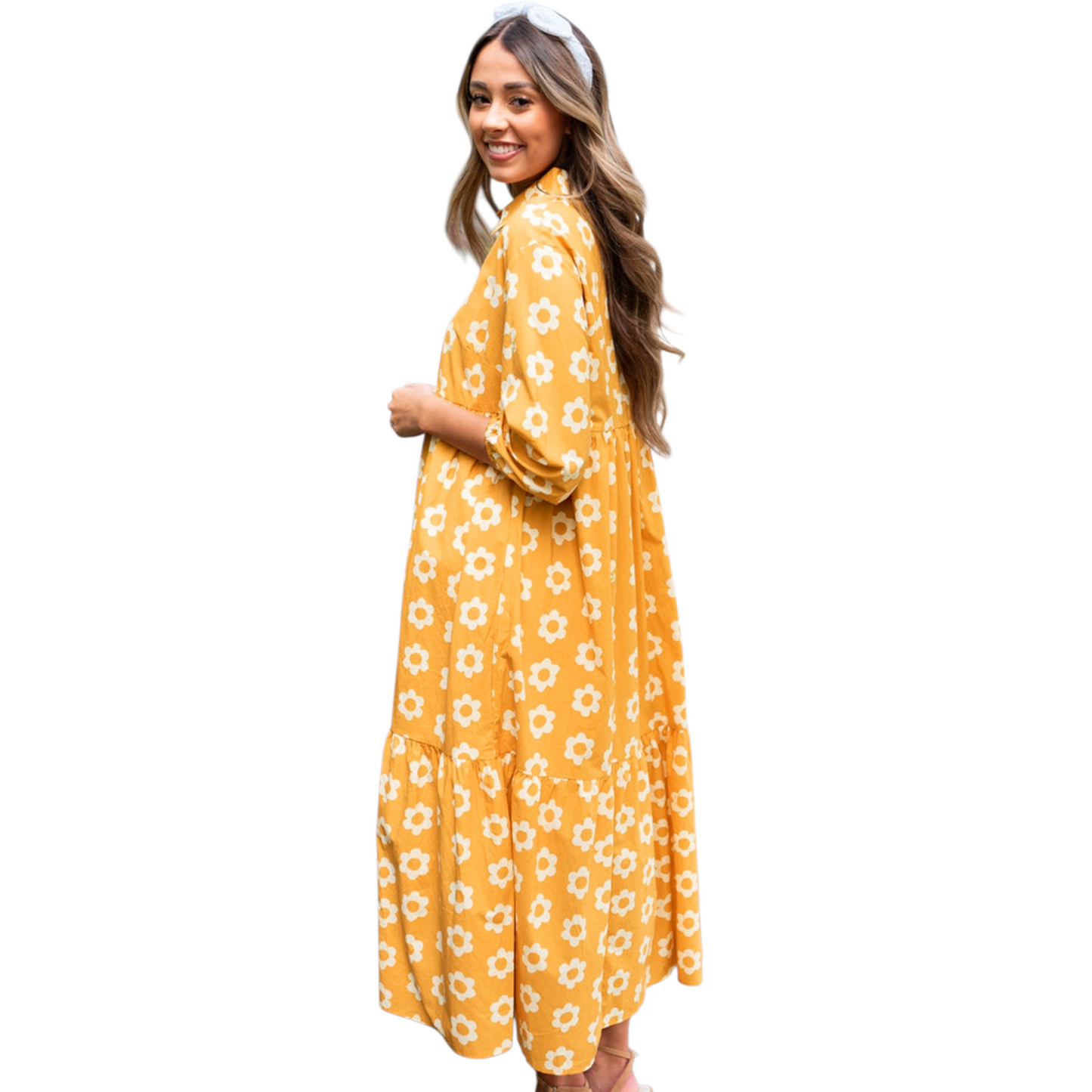 Side view of a woman wearing a yellow and white daisy print maxi dress with a collared neckline and button-down front.