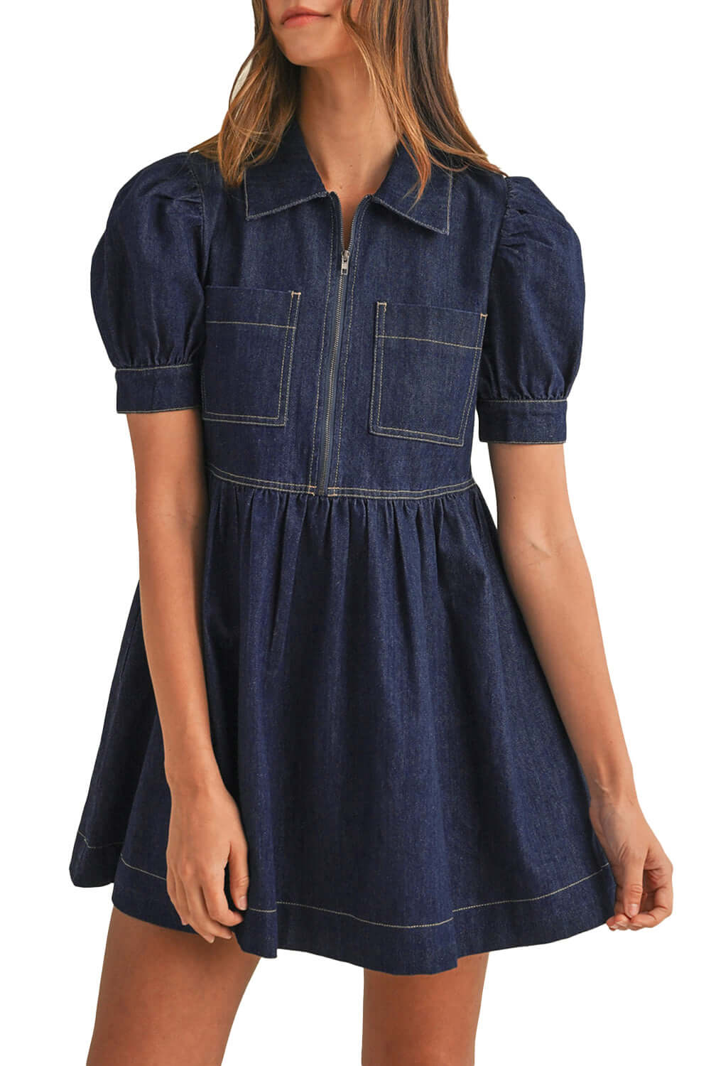 Woman in a dark blue denim flowy mini dress with short puff sleeves, posing for a youthful and aesthetic look.