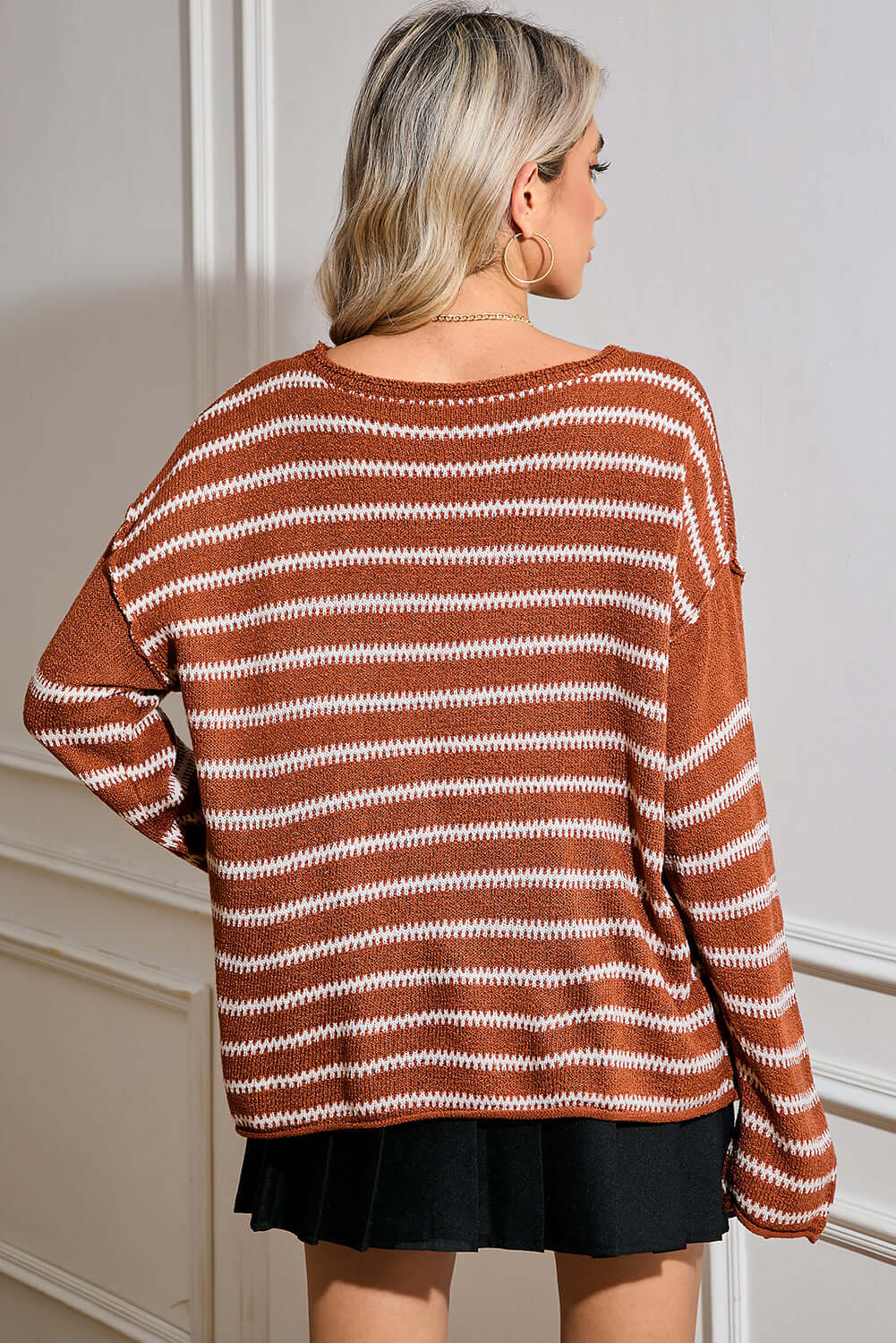 Back view of the brown striped jumper, highlighting its relaxed drape and long sleeves.