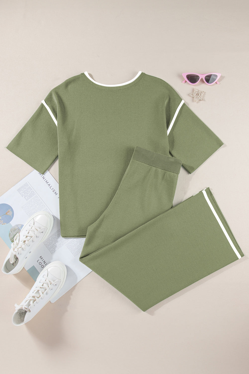 Green outfit with pants and sneakers on a light background