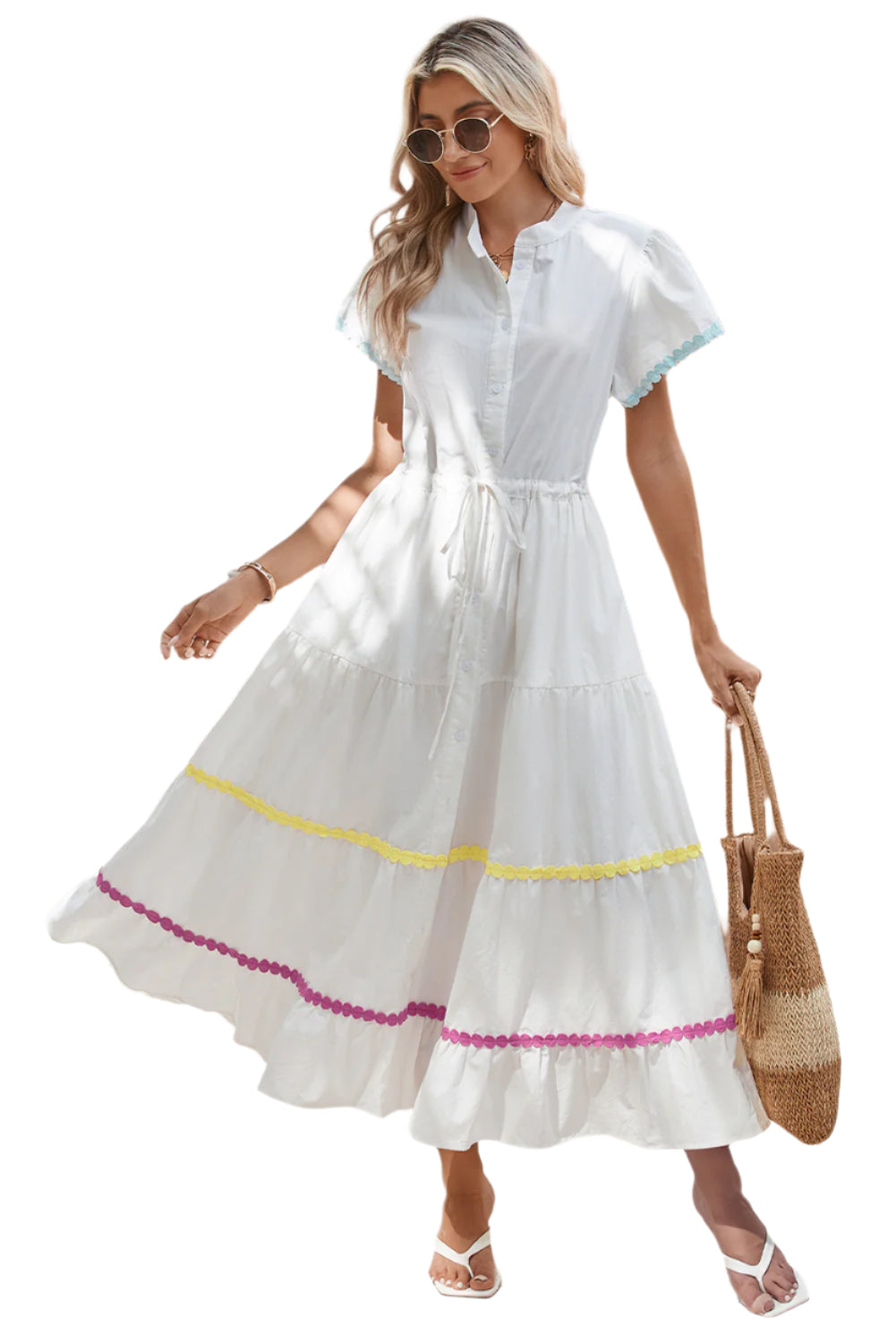 Full front view of a model standing in a white tiered shirt dress with short sleeves and a waist tie.