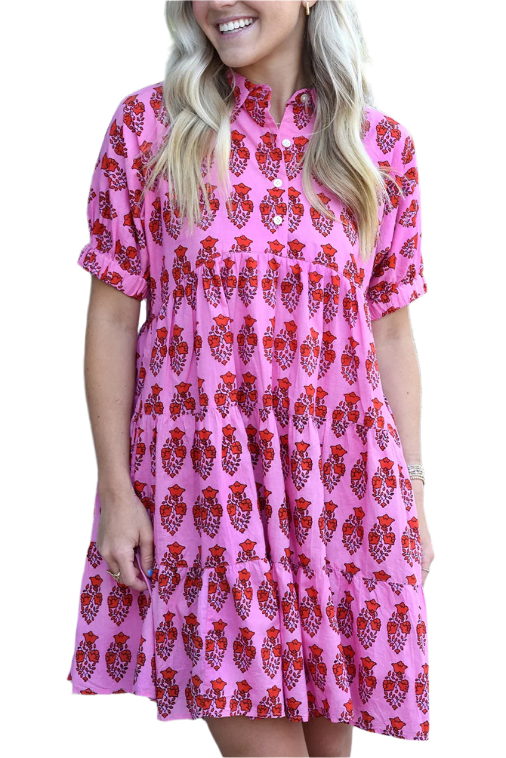 The front side of a pink floral tiered mini dress, featuring short sleeves and a tiered silhouette. Perfect for spring and summer occasions.
