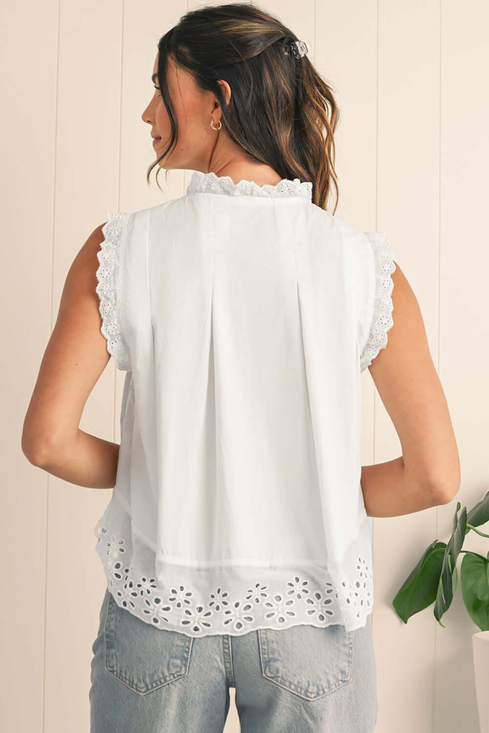 Back view of a lightweight white sleeveless blouse showcasing feminine lace accents.
