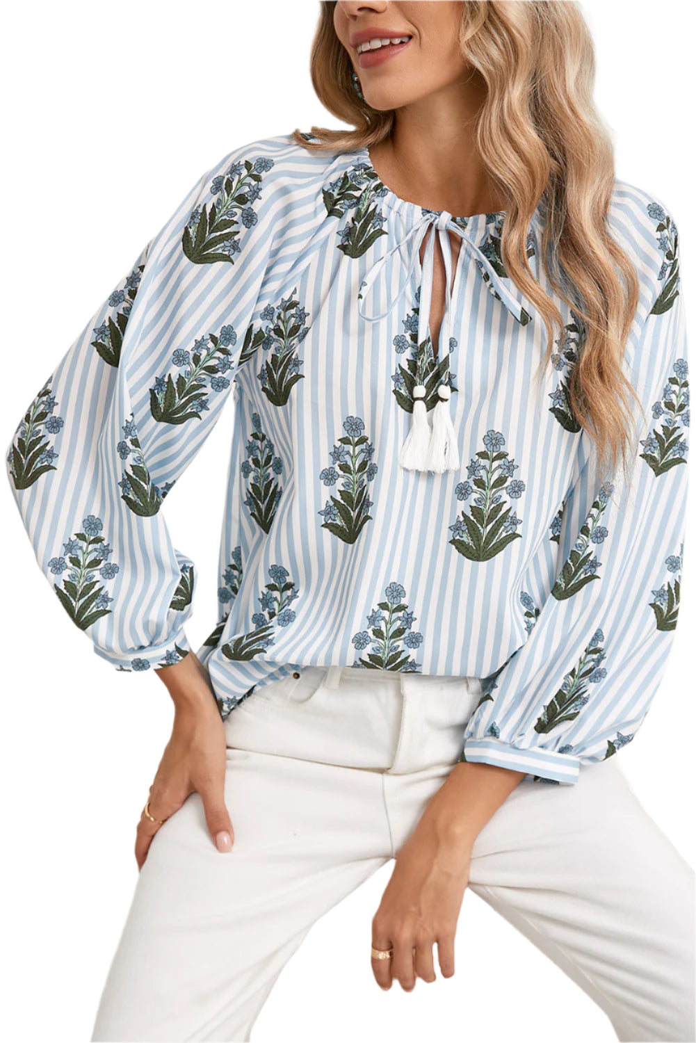 Front view of a blue floral striped blouse with long sleeves, perfect for spring and summer, worn by a model sitting on a wooden stool in a boho-chic style.