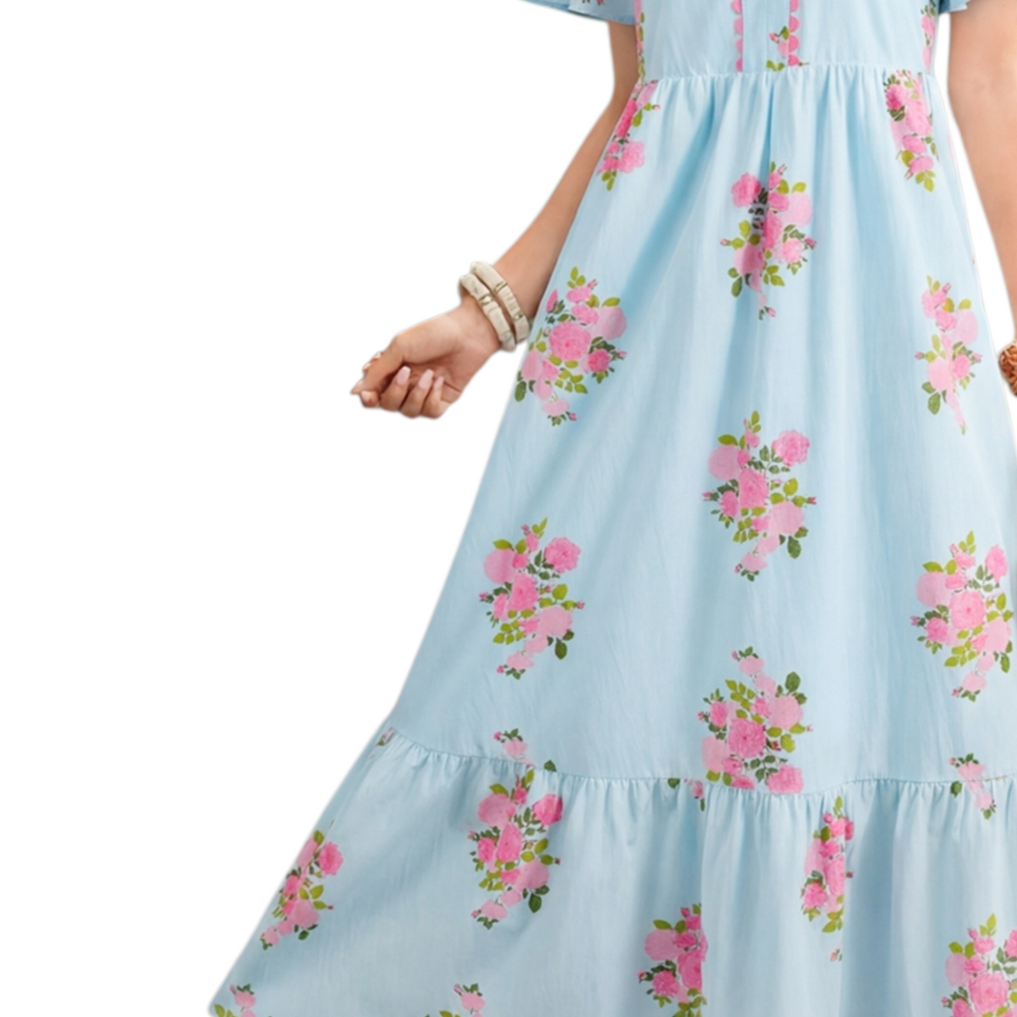 A woman wearing a light blue floral maxi dress with pink rose patterns, featuring flutter short sleeves and a notched neckline. Skirt view.
