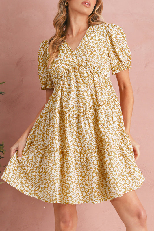 Woman wearing a yellow floral dress against a pink background